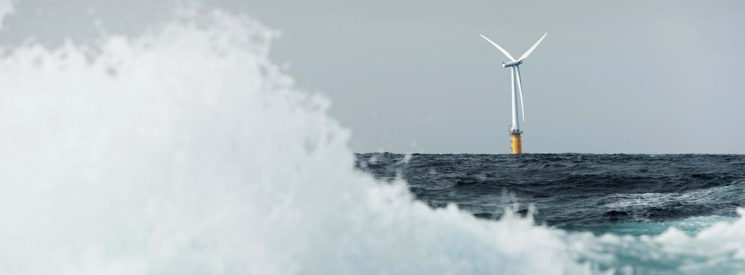 Floating offshore wind turbine on the horizon with large wave in the foreground-© Equinor